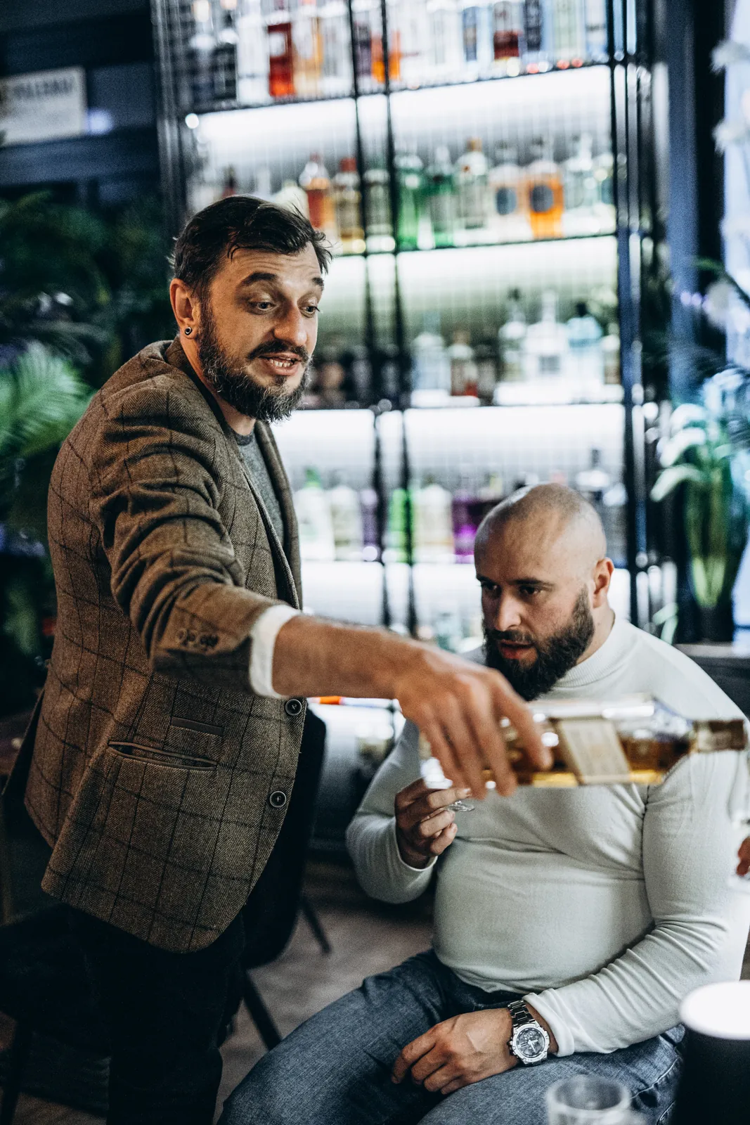 Prowadzący nalewa alkohol do kieliszka podczas degustacji w La Musica